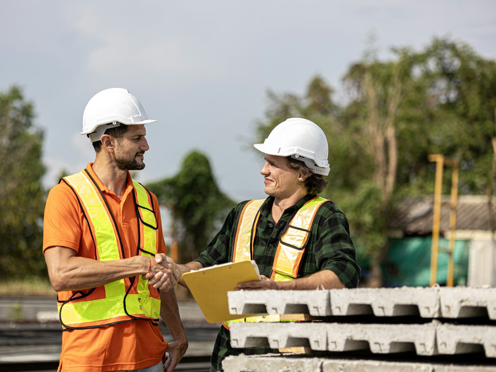 Construction business owners shaking hands on a funded deal at their job site